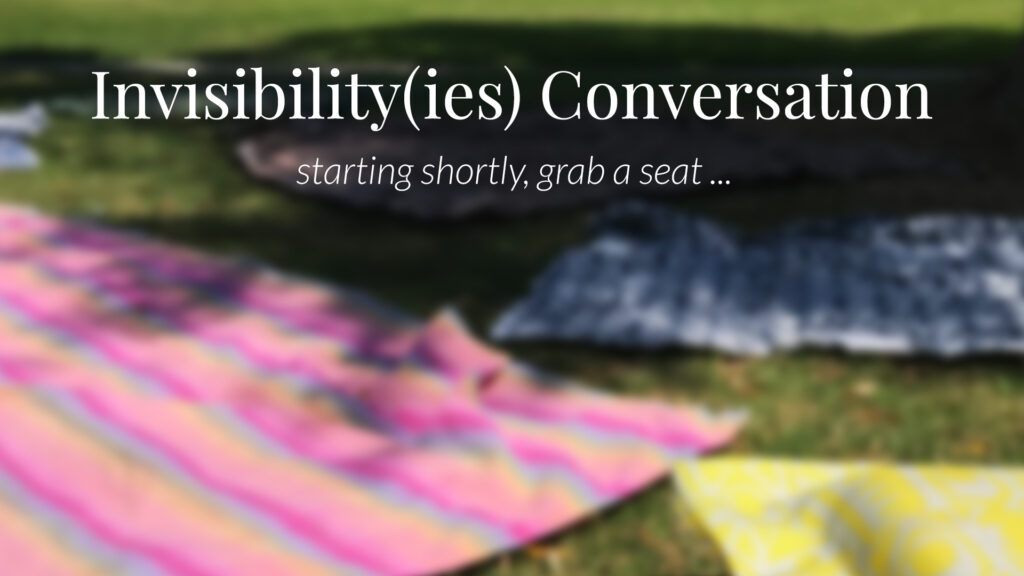 Invisibility(ies) — “Take a Seat” Blurred outdoor view of blankets and cushions on grass with the text “Invisibility(ies) Conversation — starting shortly, grab a seat …”