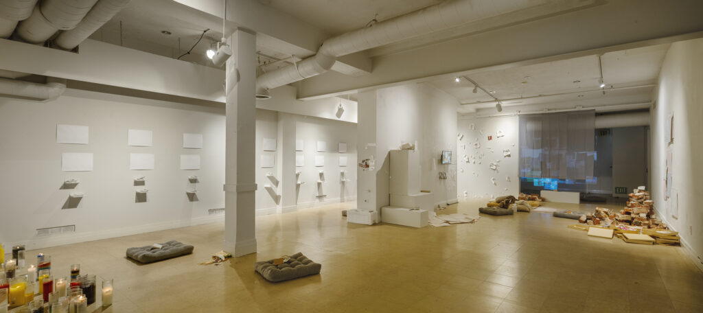 Installation view of Nicole Rademacher’s The sky broke when I was allowed to fly at LA Artcore, showing works across the gallery including drawings, porcelain, video, bricks, and floor cushions.